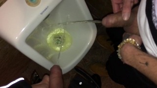 Jongens pissen en spugen samen op het urinoir na wat cocktails