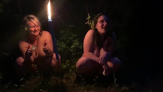 Två tjejer kissar i skogen på en fest