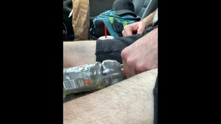 Wanhopig aan de kant van de openbare snelweg pissen in fles vol blaas urine busje