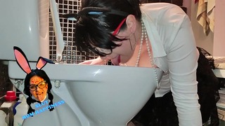 Prostituta madura de banheiro humano com peitos enormes lambe o vaso sanitário.