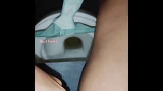 Behåret pige pisser på det offentlige toilet i et indkøbscenter