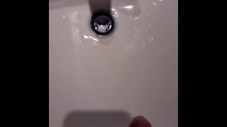 Hoping not to get caught while peeing in the bathroom sink.