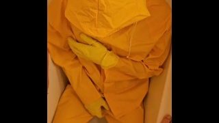 Pisser sur des vêtements de pluie jaunes avec des gants jaunes et un masque en latex